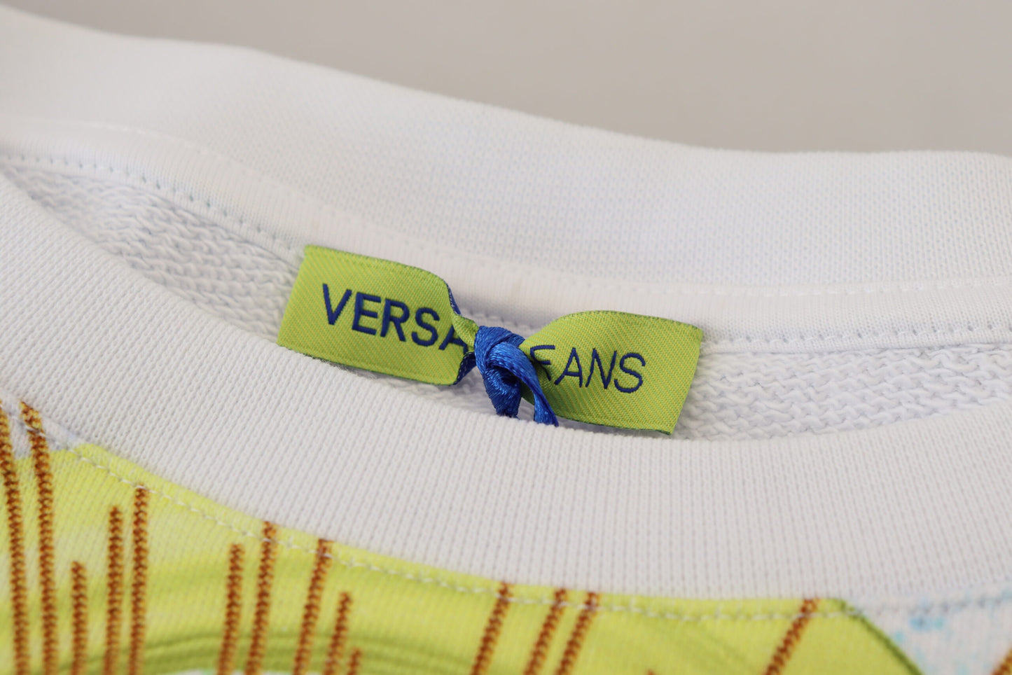 Suéter elegante de cuello redondo con estampado gráfico blanco de Versace Jeans